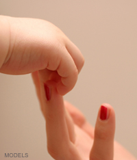 woman holding baby's hand