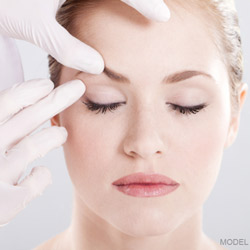 plastic surgeon checking woman's wrinkles