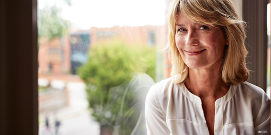 An older woman smiling after having facelift surgery.