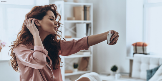 Woman with natural looking fillers taking a selfie for Instagram