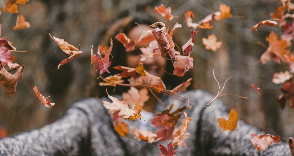 Woman throwing fall leaves -September promo