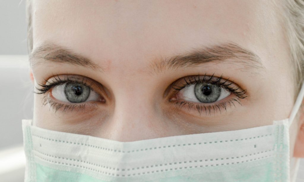 Woman with beautiful eyes wearing a mask after eye rejuvenation