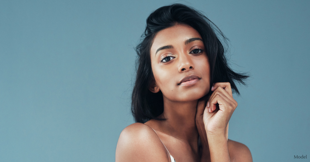 Woman (model) holds a hand up to her chin